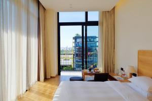a hotel room with a bed and a large window at Taihua Wutong Hotel in Bao'an