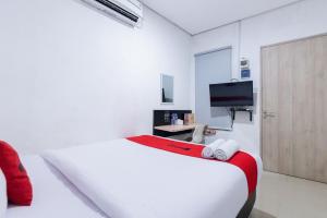 Habitación blanca con cama y TV en RedDoorz Plus Syariah near Mall Pondok Indah, en Yakarta