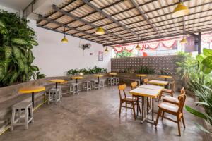 um restaurante com mesas, cadeiras e plantas em RedDoorz Plus Syariah near Mall Pondok Indah em Jakarta