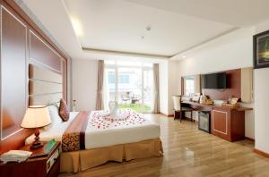 a hotel room with a large bed and a desk at Paris Nha Trang Hotel in Nha Trang