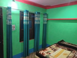 a bedroom with green walls and a window and a bed at Bajwal Home-Stay & Guest-House in Sari