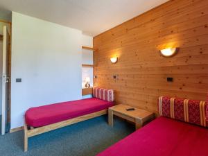 ラ・プラーニュにあるAppartement La Plagne, 1 pièce, 4 personnes - FR-1-353-13のベッド2台とテーブルが備わる小さな客室です。