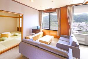 a living room with a couch and a large window at TAOYA Akiu in Sendai