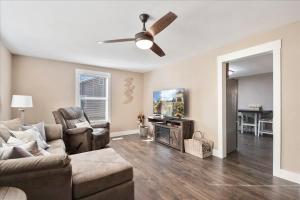 uma sala de estar com um sofá e uma ventoinha de tecto em • Maverick House • Downtown Siloam Springs em Siloam Springs