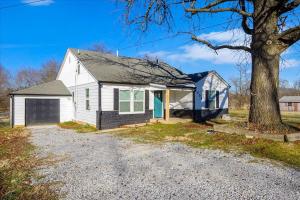 a white house with a tree and a driveway at • Maverick House • Downtown Siloam Springs in Siloam Springs