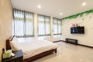 1 dormitorio con 1 cama y TV de pantalla plana en 甯好甯居NinGs HouSe, en Yilan City