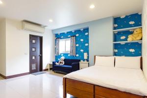 a bedroom with a bed and a blue wall with stuffed animals at 甯好甯居NinGs HouSe in Yilan City