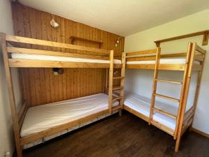 ラ・プラーニュにあるAppartement La Plagne, 2 pièces, 6 personnes - FR-1-351-12の木製の壁の客室で、二段ベッド2組が備わります。