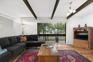 a living room with a couch and a tv at THE Beach Hive - Wifi, PET Friendly Outside Only - Inlet Side in Inverloch