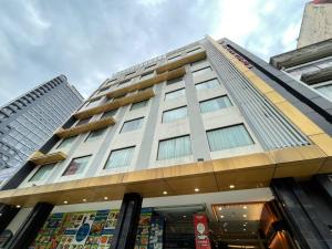 Kingston Hotel Kuala Lumpur في كوالالمبور: مبنى طويل أمامه متجر