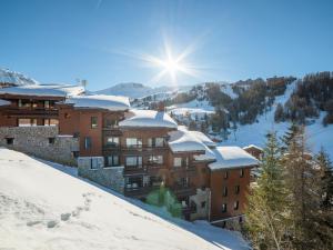 a building covered in snow with the sun behind it at Appartement Plagne 1800, 2 pièces, 5 personnes - FR-1-351-42 in Plagne 1800