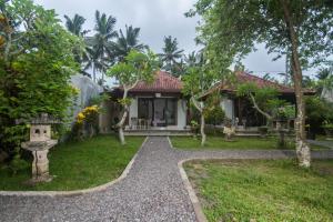 uma casa com um jardim e um caminho que o conduz em Parthi Puri Ubud em Ubud