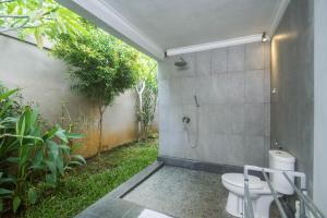 a bathroom with a shower and a toilet at Parthi Puri Ubud in Ubud