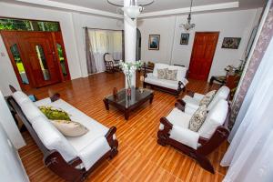 un soggiorno con mobili bianchi e pavimenti in legno di Amancay House a San Cristóbal