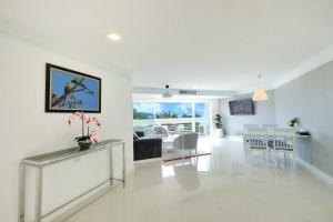 ein weißes Wohnzimmer mit einem Sofa und einem Tisch in der Unterkunft Andaman Beach Suites Hotel - SHA Extra Plus in Patong Beach