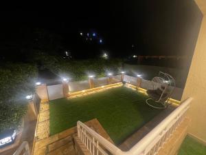 eine Aussicht auf den Garten in der Nacht mit Lichtern in der Unterkunft شقة فندقية في مدينتي in Madinaty