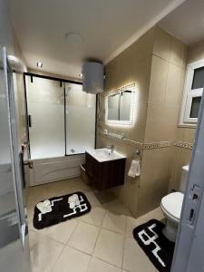 ein Bad mit einer Dusche, einem Waschbecken und einem WC in der Unterkunft شقة فندقية في مدينتي in Madinaty