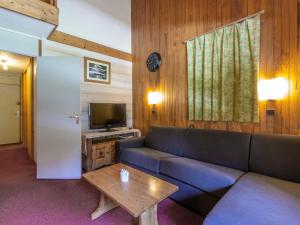 ein Wohnzimmer mit einem Sofa und einem TV in der Unterkunft Appartement Valmorel, 3 pièces, 7 personnes - FR-1-356-362 in Valmorel