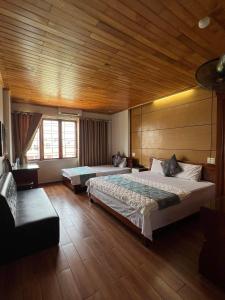 Ðoan XáにあるThanh Bình Hotelの木製の天井が特徴のベッドルーム1室(ベッド2台付)