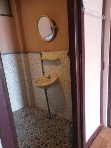 a bathroom with a sink and a mirror at Champa Guesthouse in Muang Không