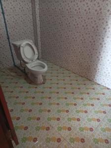 a bathroom with a toilet in a tiled floor at Champa Guesthouse in Muang Không