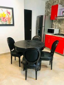 a black table and chairs in a kitchen with a refrigerator at Loft estudio centrico in Ciudad del Carmen