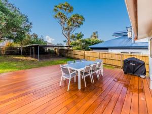 a patio with a table and chairs on a wooden deck at Pescarina Free Wifi Netflix in Inverloch