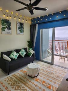 ein Wohnzimmer mit einem Sofa und einem Balkon in der Unterkunft Camping Styles 3 Emerald Avenue Cameron Highlands 10Pax 117 Wifi in Brinchang