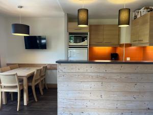 a kitchen with a wooden counter and a table at Appartement Plagne 1800, 2 pièces, 5 personnes - FR-1-351-143 in La Plagne Tarentaise