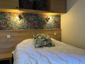 ein Bett mit einem Kissen darauf in einem Schlafzimmer in der Unterkunft Appartement Plagne 1800, 2 pièces, 5 personnes - FR-1-351-143 in La Plagne Tarentaise