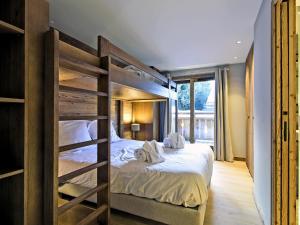 a bedroom with two bunk beds with white sheets at Charmant Appartement à Méribel - 3 Chambres, 6 Pers, Balcon & TV, Services Inclus - FR-1-613-33 in Méribel
