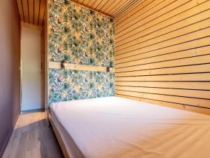 a bed in a room with a wooden wall at Appartement La Plagne-Tarentaise, 2 pièces, 4 personnes - FR-1-351-152 in La Plagne Tarentaise