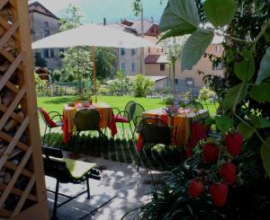 d'une terrasse avec des tables, des chaises et un parasol. dans l'établissement Le Colombe, à Malè