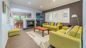 a living room with two yellow couches and a fireplace at Oceans 11 Surfside Wifi Foxtel Pet Friendly Outside Only in Inverloch