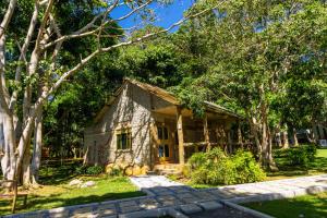 a small stone house in the middle of trees at Sundiata Beach Resort in Entebbe