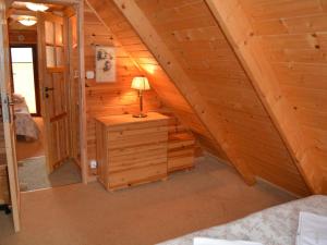 a attic room with a bed and a lamp on a dresser at Holiday cottages near the sea, Sarbinowo in Sarbinowo
