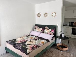 a bedroom with a bed with floral pillows at Charmantes Apartment in Offenburg