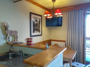 a kitchen with a sink and a table with a deer statue at Appartement Valmorel, 2 pièces, 4 personnes - FR-1-356-424 in Valmorel