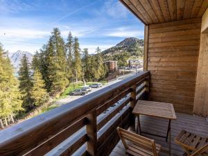 a wooden balcony with a bench and a view of a street at Appartement La Plagne-Tarentaise, 3 pièces, 6 personnes - FR-1-351-178 in La Plagne Tarentaise