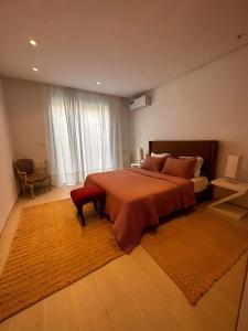 una camera da letto con un grande letto con una coperta rossa di App avec jardin dans un hôtel a Gammarth