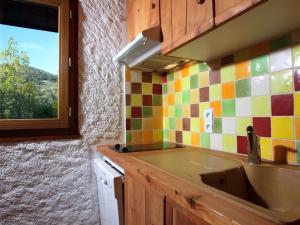 a kitchen with a sink and a colorful tiled wall at Appartement Saint-Chaffrey , 2 pièces, 4 personnes - FR-1-762-14 in Saint-Chaffrey