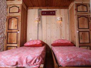 two beds in a room with wooden walls at Appartement Saint-Chaffrey , 2 pièces, 4 personnes - FR-1-762-14 in Saint-Chaffrey