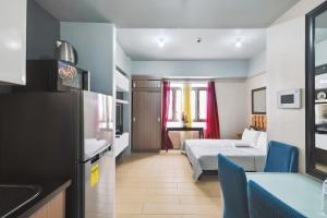 Una pequeña habitación con una cama y una cocina. en Tess and Tessha Condotel near T3 Airport, en Manila