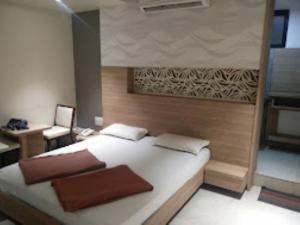 1 dormitorio con 1 cama blanca grande y escritorio en Hotel Sagar Executive BEED, en Bīr