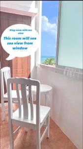 a white chair in a room with a window at 88 House Patong in Patong Beach