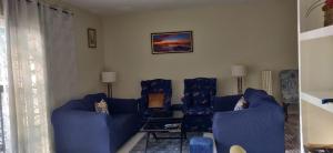 a living room with two blue couches and a table at Guango Grove Cozy Corner in Montego Bay