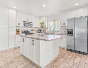 een keuken met witte kasten en een roestvrijstalen koelkast bij Villa Descanso in Oceanside