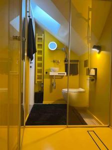 bagno giallo con lavandino e servizi igienici di KAUNAS ATTIC, Apartment in the heart of Kaunas a Kaunas