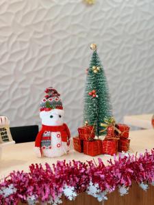 Un árbol de Navidad y un muñeco de nieve en una mesa con regalos en BLUE OCEAN BOUTIQUE HOTEL - Boracay Island, en Boracay