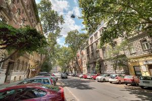 una fila de autos estacionados al lado de una calle en Little Americas Westend Apartments, en Budapest